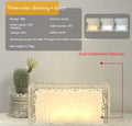 Clear acrylic geometric ice cube shaped night lamp glowing with soft blue LED light on a dark surface.