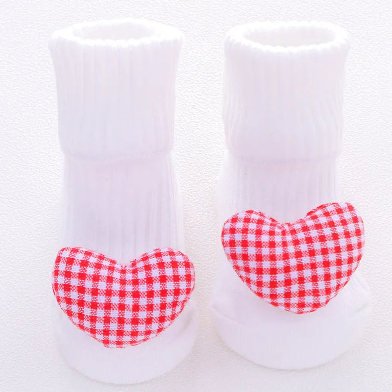 Cotton baby floor socks in various colours and patterns including pink bows, grey stars, and panda design.