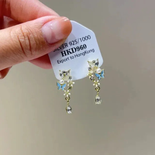 Geometric silver-tone alloy ear clips with rhinestones and hanging tassels, showing heart-shaped details