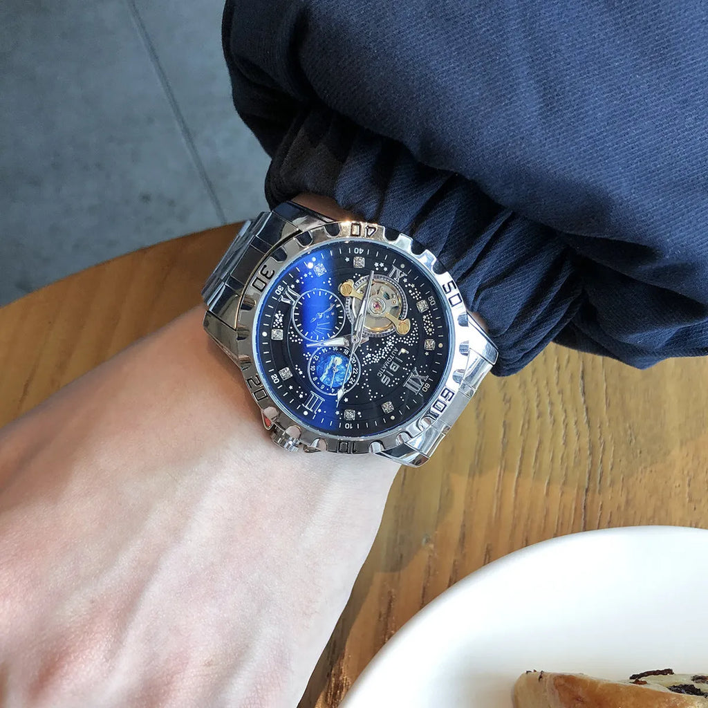 Men's silver case automatic watch with black starry luminous dial on a black steel belt.