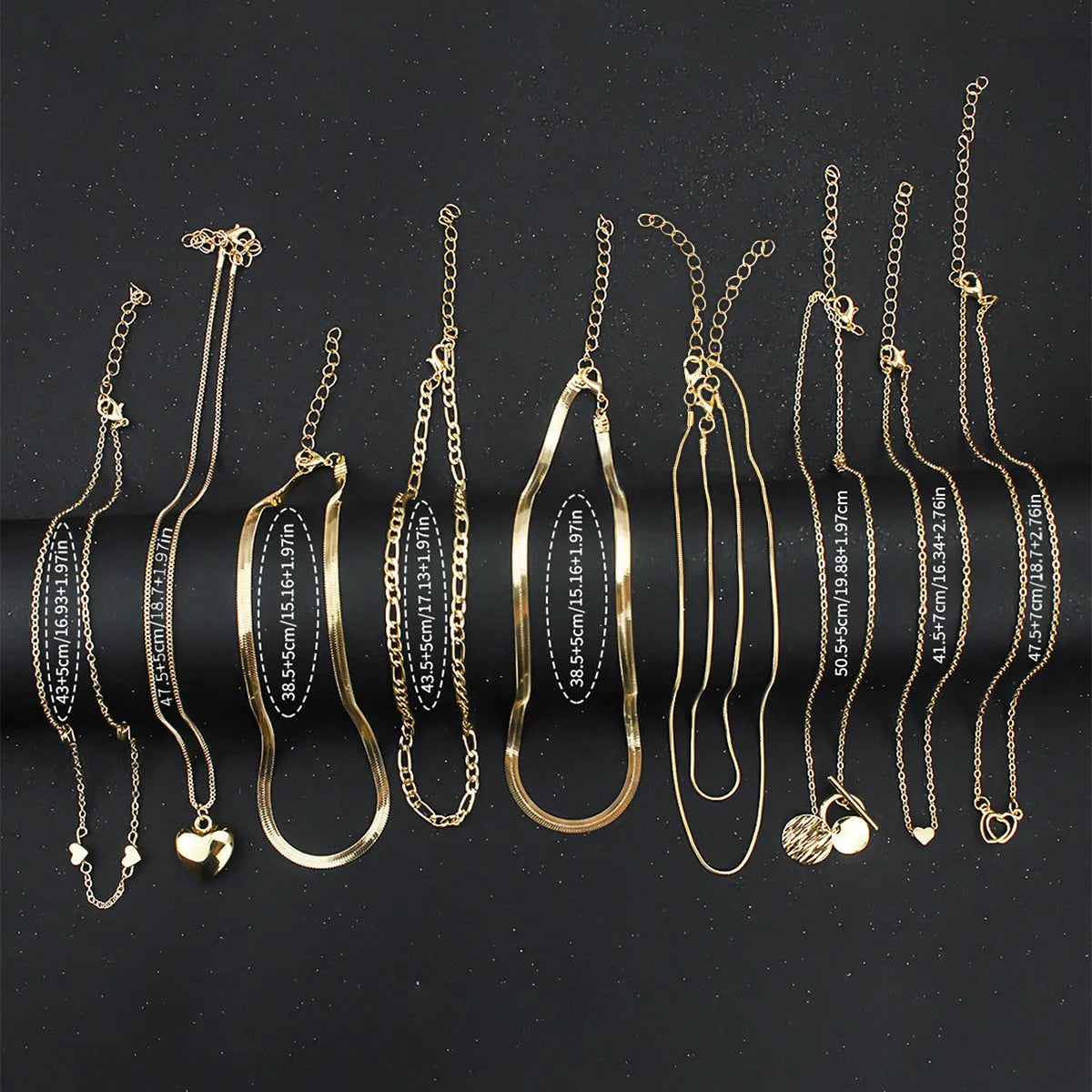 Ten gold necklaces with snake bone chains and alloy pendants displayed as complete jewellery set