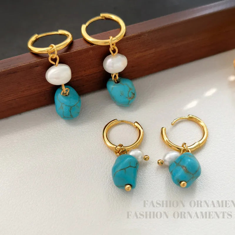 A pair of long dangle earrings with an irregular turquoise geometric clip and a cultured pearl drop on a copper setting.