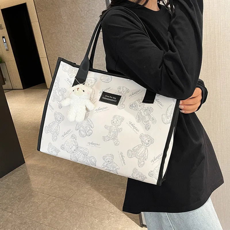 Women's printed canvas tote bag with rhombus pattern showing horizontal square shape and shoulder strap