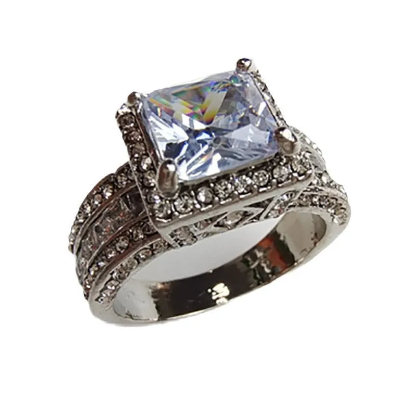 Close-up of a geometric round silver-tone women's ring with a polished electroplated finish, shown in gold and white colour options.