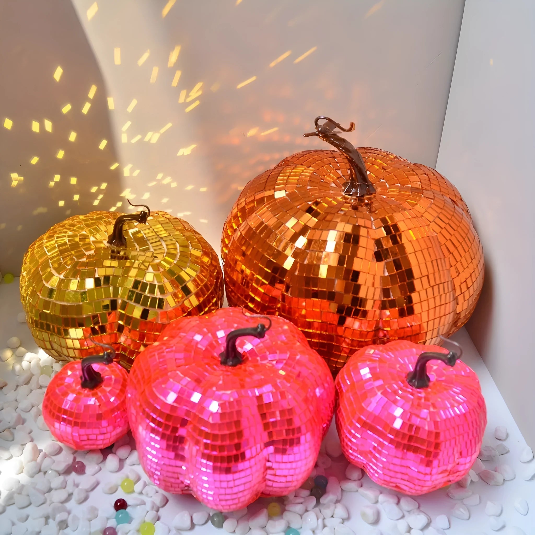 Chinese style glass Halloween pumpkin decoration in five different sizes on a dark surface.