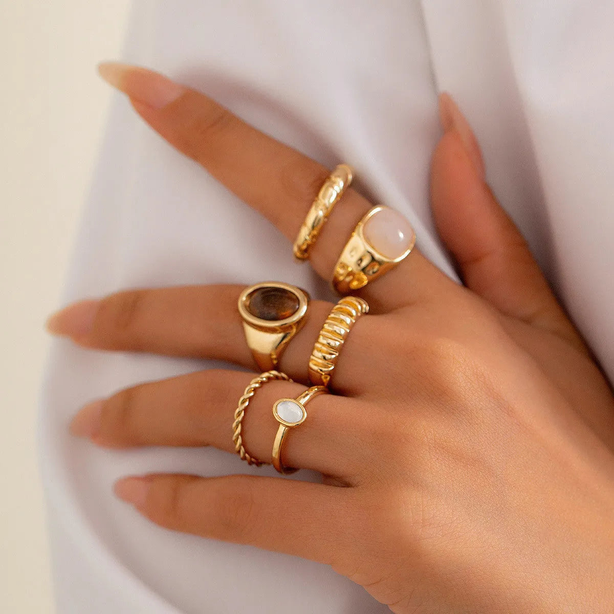 Six irregular geometric alloy rings in light gold electroplated finish arranged as jewellery set