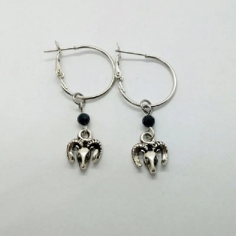 A pair of silver-coloured alloy round earrings featuring a Tibetan antelope design motif.