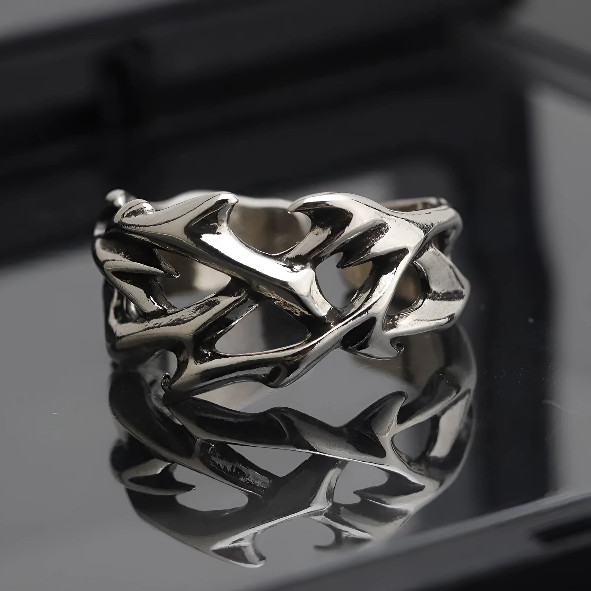Copper geometric thorn and flower design ring with an adjustable opening on a dark background.
