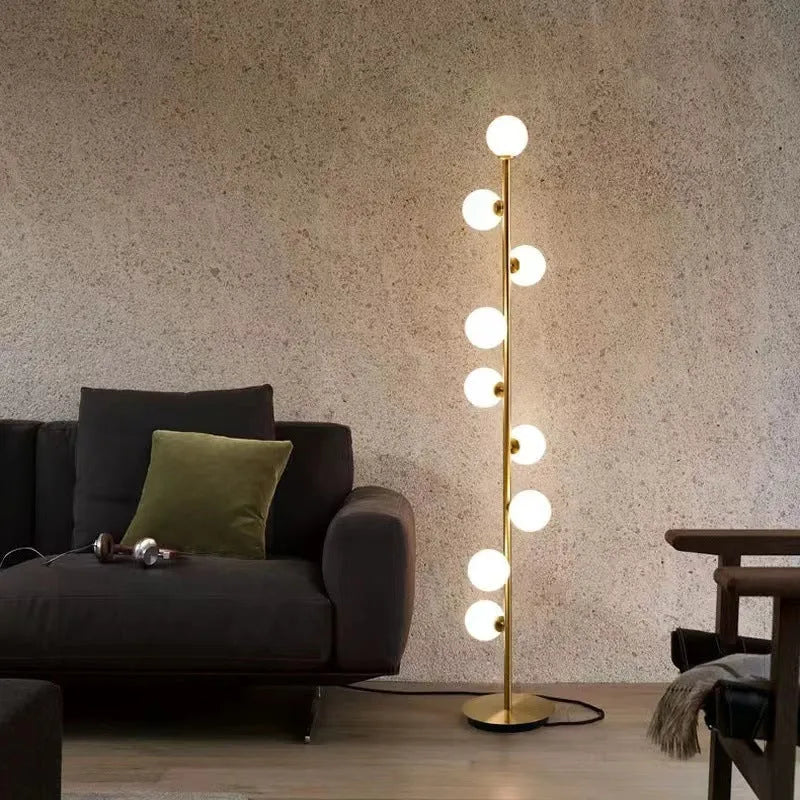 Tall modern floor lamp with glass shade and ironwork base on a wooden floor, showing minimalist Nordic design.