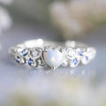 Women's white heart-shaped ring with flower opal ocean pattern detail in peach heart design