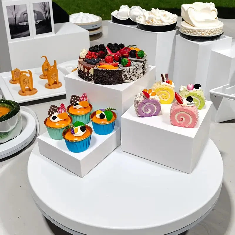 White plastic modular dessert display stand cubes stacked to form a tiered tabletop cake stand.