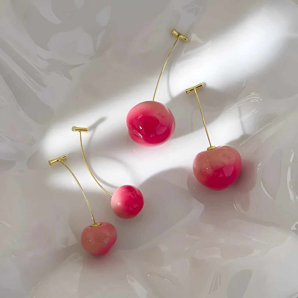 A pair of peach-shaped acrylic earrings on copper studs, shown in small and large size options.