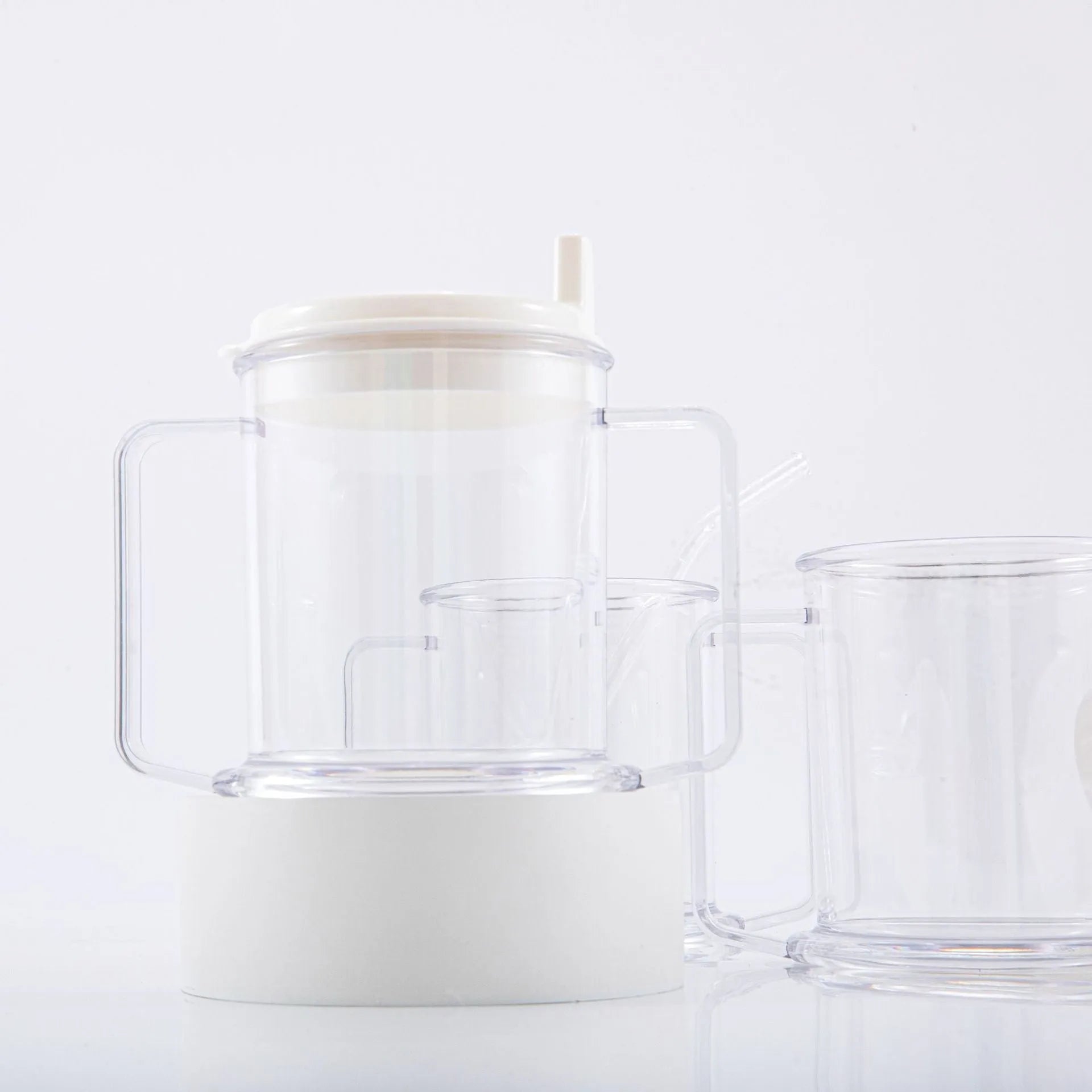Transparent plastic drinking cup with spill-proof design on a plain background.