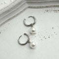 Geometric women's pearl drop earrings with alloy frame and titanium steel fittings.