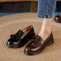 Women's brown leather loafers with tassel detail and a low chunky heel.