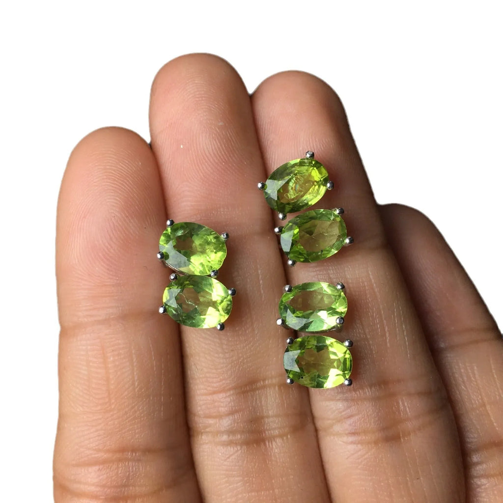 Close-up of natural grass green olivine stud earrings in sterling silver geometric setting.