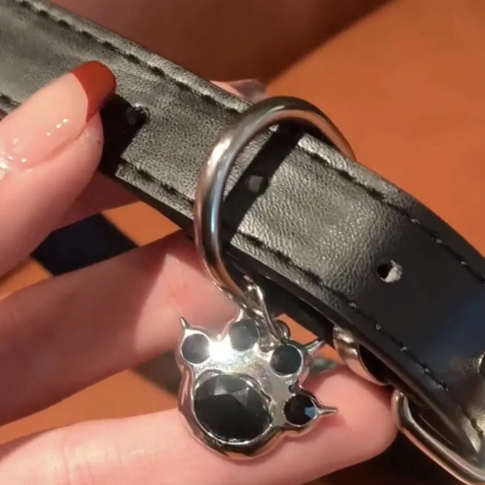 Black adjustable leather dog collar with decorative bone charm on a regular chain