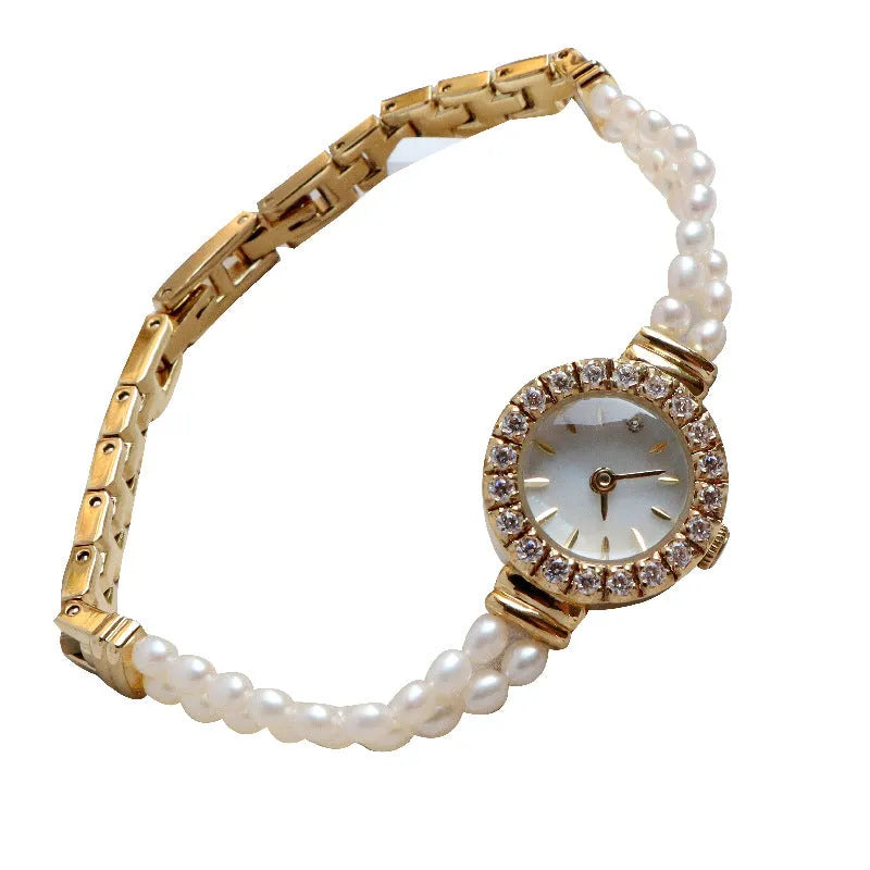 Women's light gold bracelet watch with a freshwater pearl charm and round mineral glass dial.