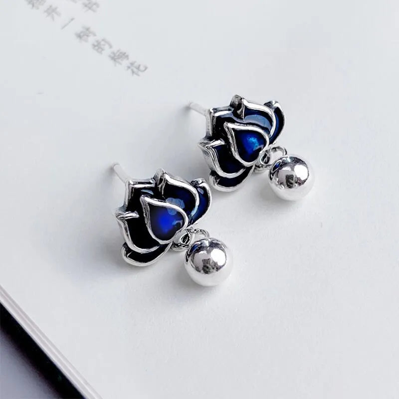Blue lotus flower and seedpod tassel drop earrings with silver needle details on alloy studs.