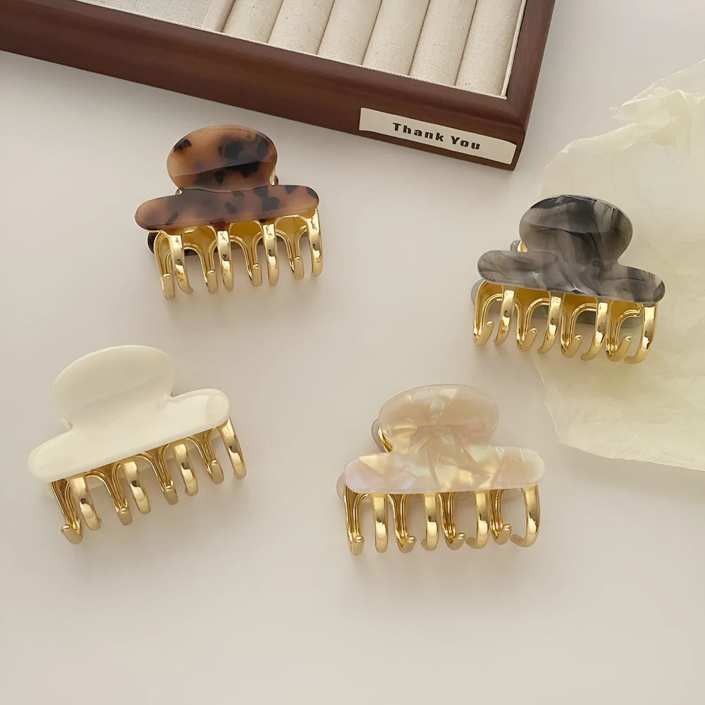 Medium metal grip women's barrette in retro acetate style, alloy acrylic construction, shown in one of four colour options.