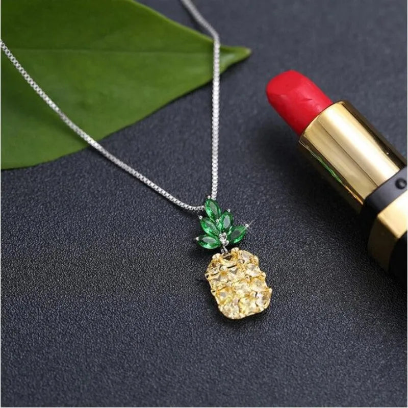 Silver coloured geometric pineapple diamond pendant necklace on a chain.