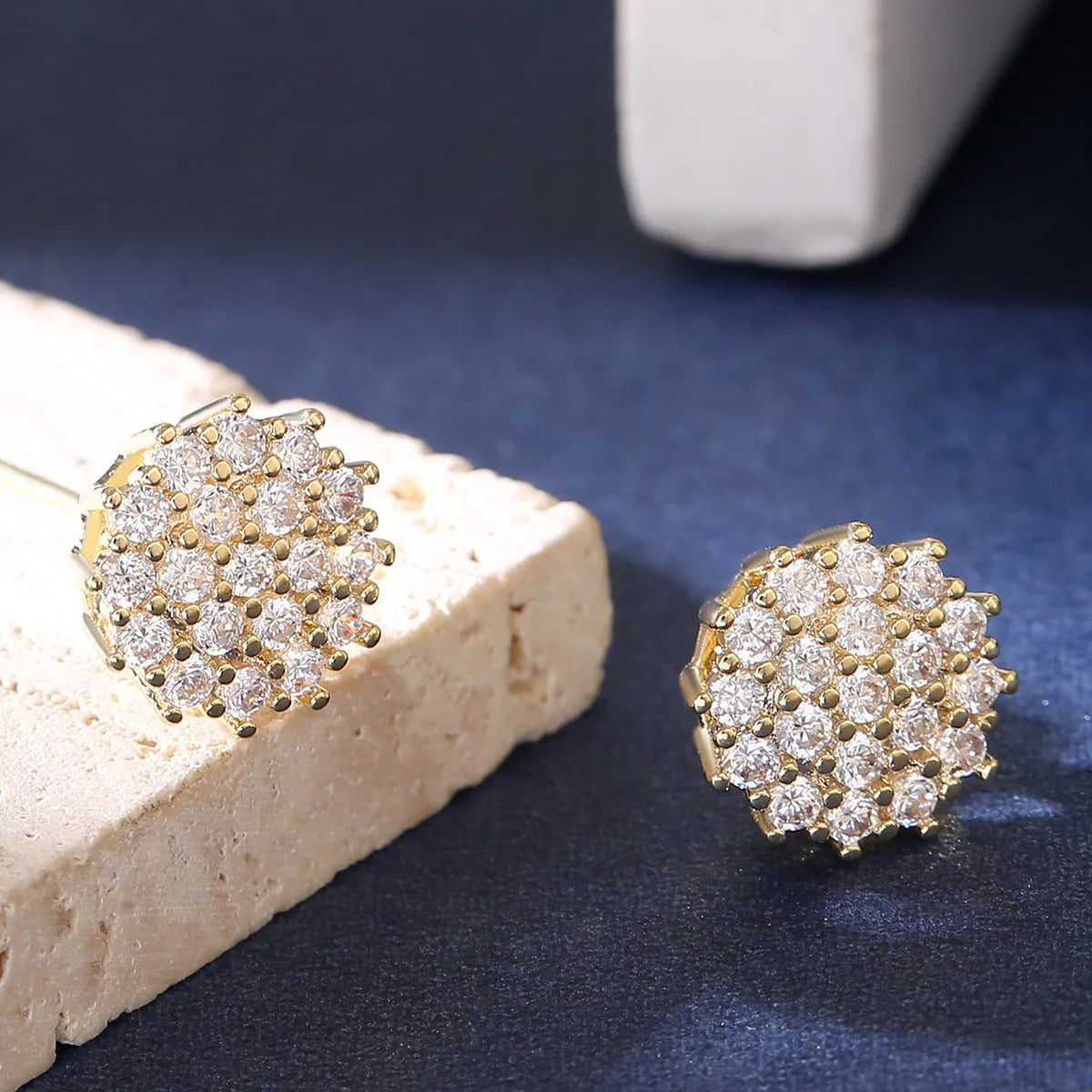 Pair of copper electroplated stud earrings in silver with irregular and round shapes on white background
