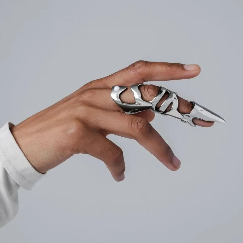 Silver alloy punk armour finger covers laid out on a dark surface.