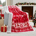 Soft red plush Christmas blanket draped over a sofa, showing its textured flannel fabric.