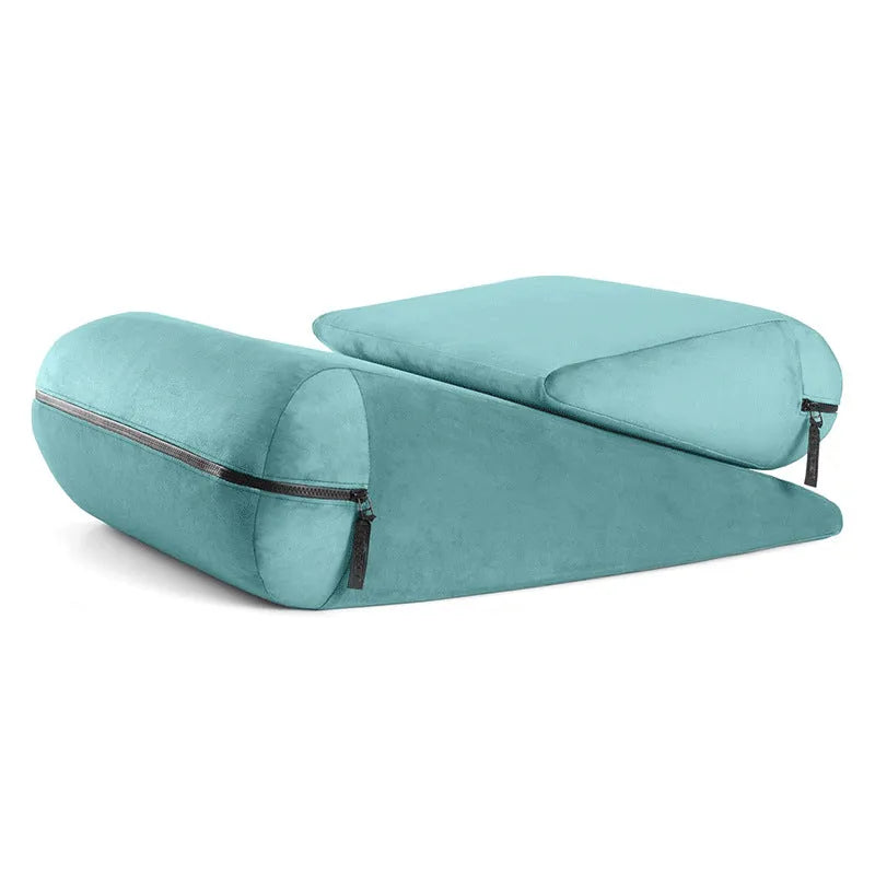 High density grey wedge-shaped support pillow with embroidered texture on a sofa.