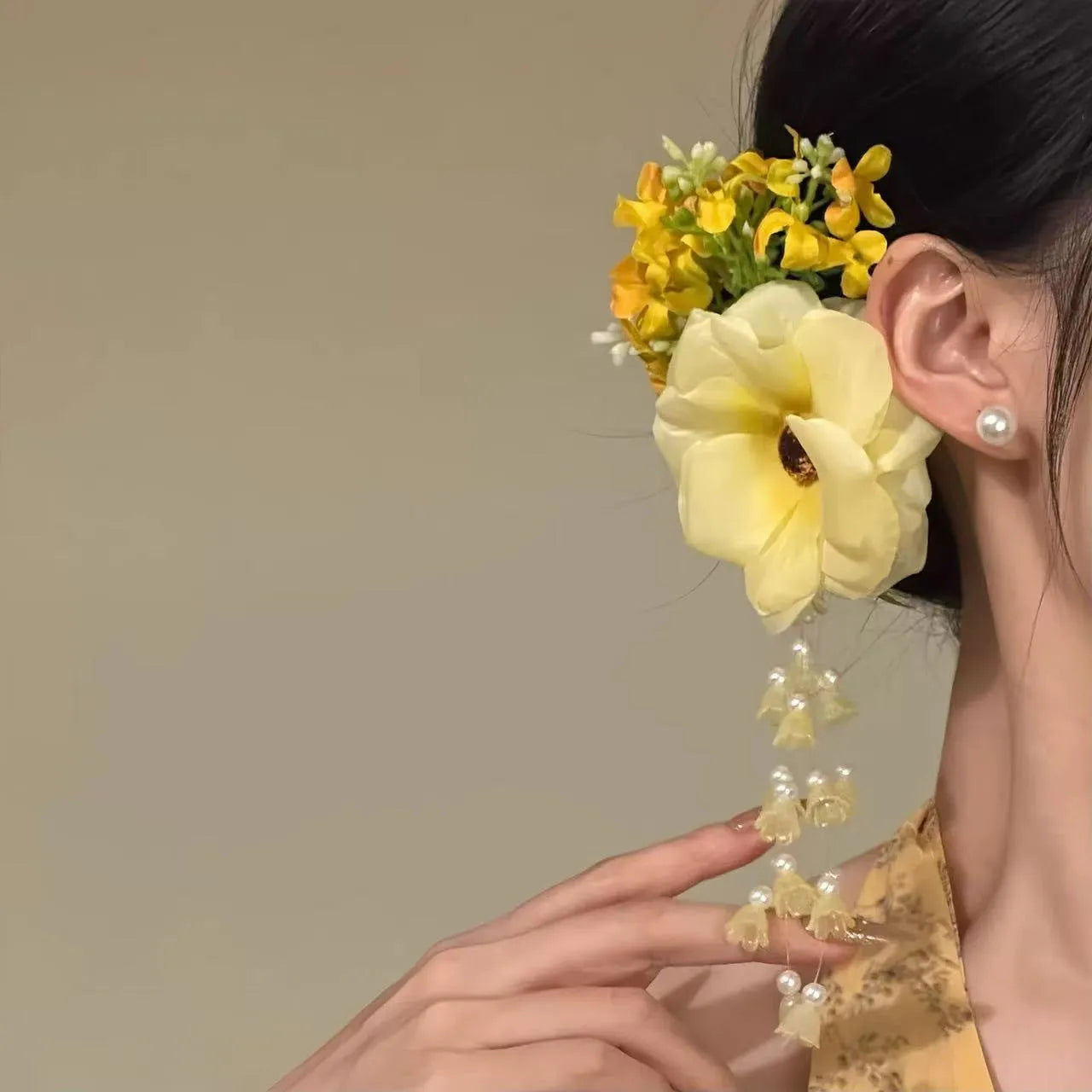 Yellow and purple floral hair clip with pearl accents and tassels on a side clip base.