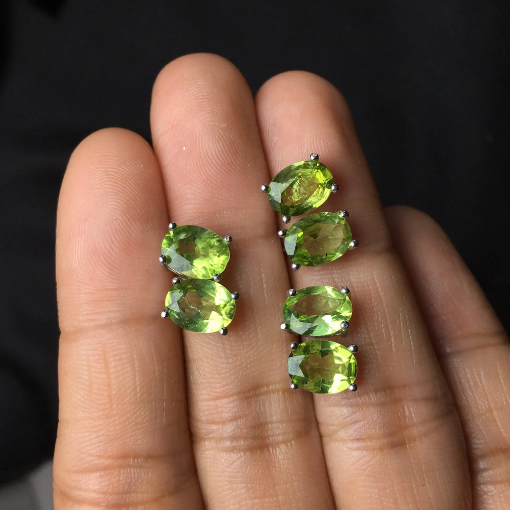 Close-up of natural grass green olivine stud earrings in sterling silver geometric setting.