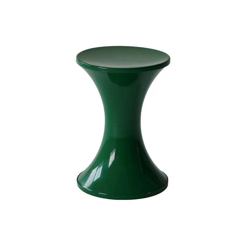 Green plastic hourglass-shaped shoe changing stool on a wooden floor.