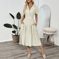 Light green commuter shirt dress with lapel collar, waist tie, and side pockets on a hanger.
