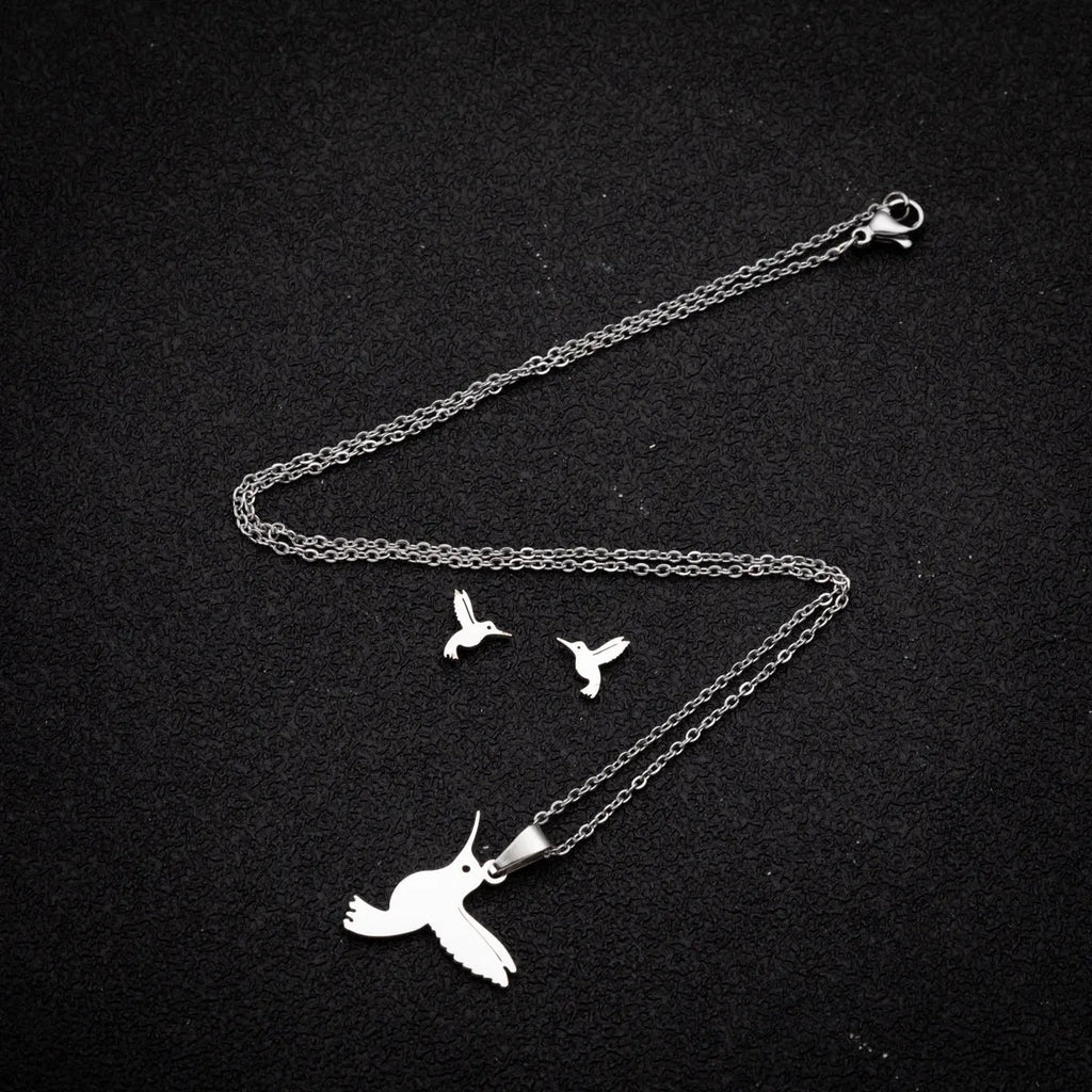Cute little animal stainless steel jewellery set with bird motif necklace and earrings in gold colour on a white background