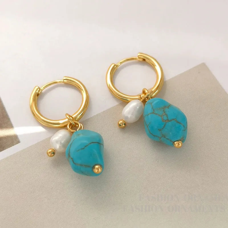 A pair of long dangle earrings with an irregular turquoise geometric clip and a cultured pearl drop on a copper setting.