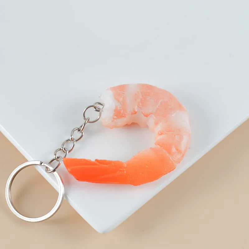 PVC injection moulded shrimp-shaped keychain with door buckle function, shown in modern simplicity style.