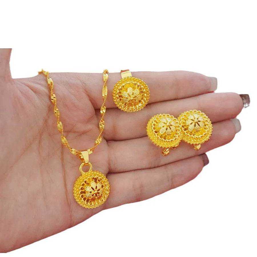 Gold-plated three-piece jewellery set with floral designs showing necklace, earrings, and ring