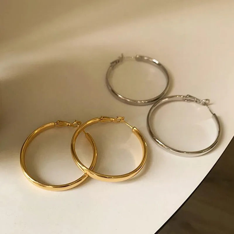 A pair of gold-coloured metal circle hoop earrings on a 40mm diameter.