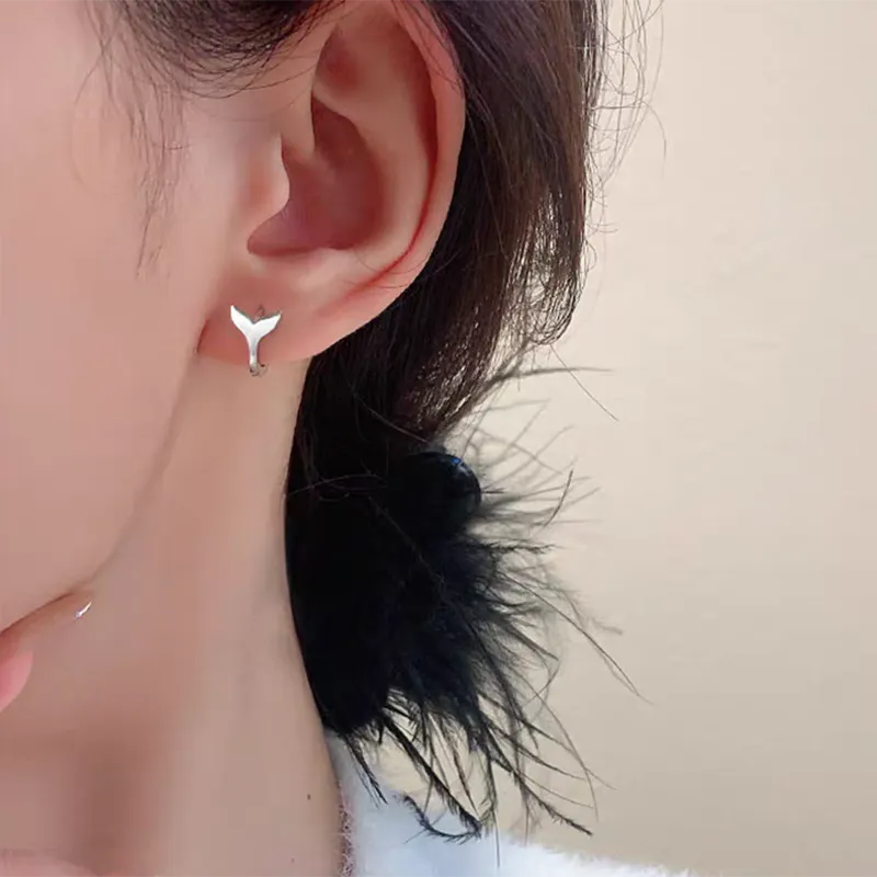 Women's fashion earrings with fishtail element design in white gold or yellow gold colour