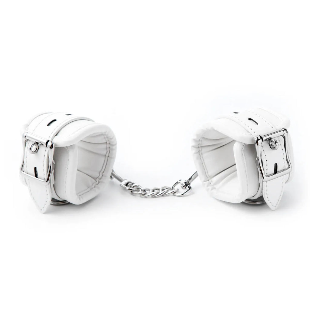 White PU sponge bondage set showing handcuffs, foot cuffs, and a neck scarf laid flat.