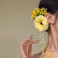 Yellow and purple floral hair clip with pearl accents and tassels on a side clip base.
