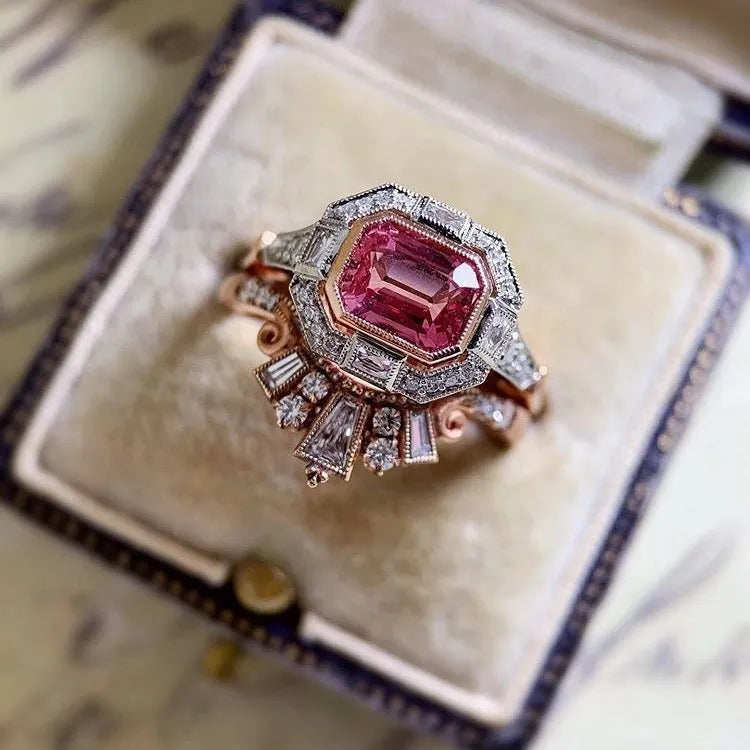 Rose gold alloy women's ring with a geometric design and ruby-coloured stone in a retro style.