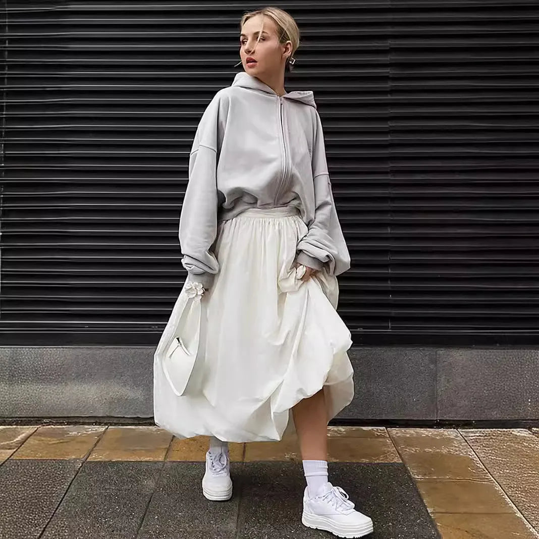 Women's solid colour long cotton skirt on a hanger, available in black and white.