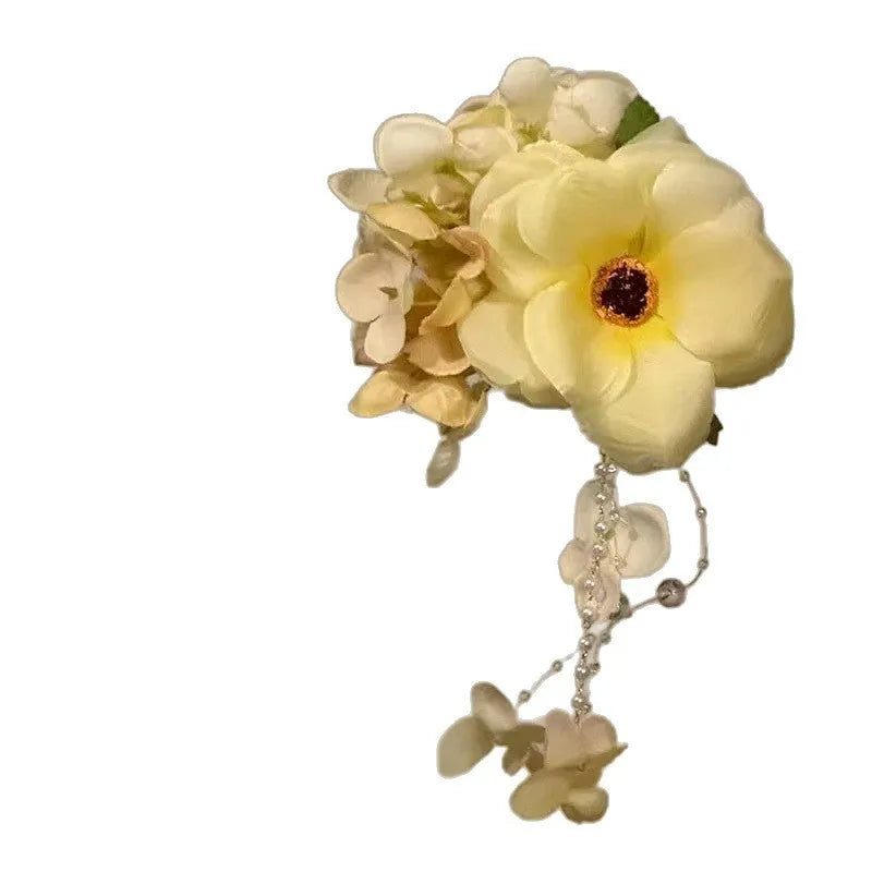 Yellow and purple floral hair clip with pearl accents and tassels on a side clip base.