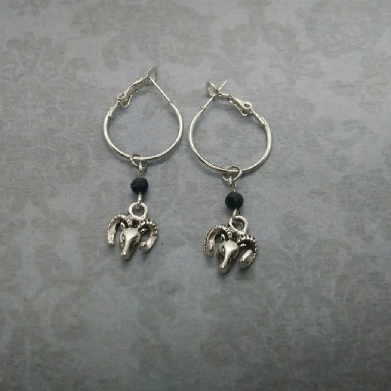 A pair of silver-coloured alloy round earrings featuring a Tibetan antelope design motif.
