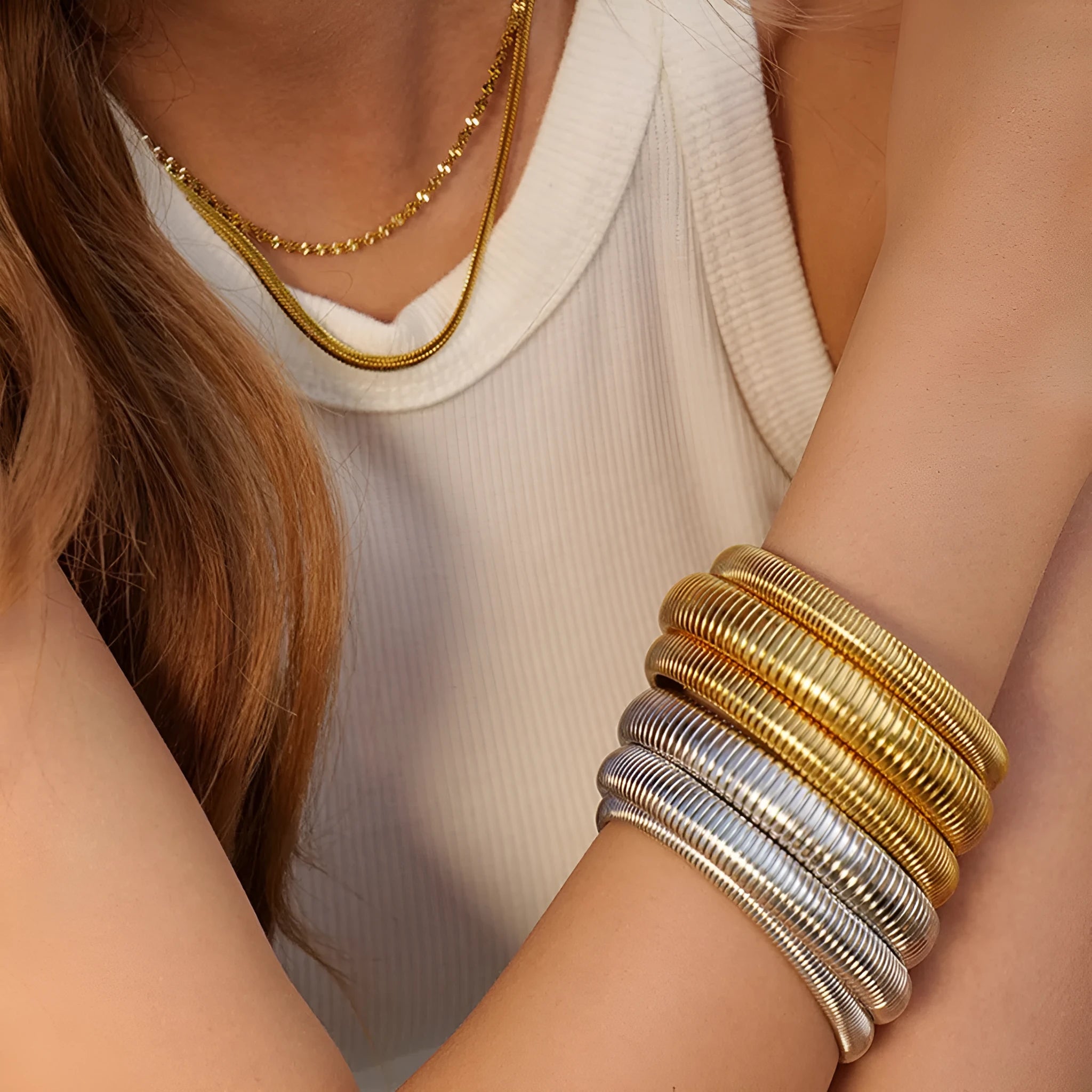 Women's titanium steel elastic bracelet with vertical stripe pattern in gold or silver, shown in various width sizes