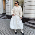 Women's solid colour long cotton skirt on a hanger, available in black and white.