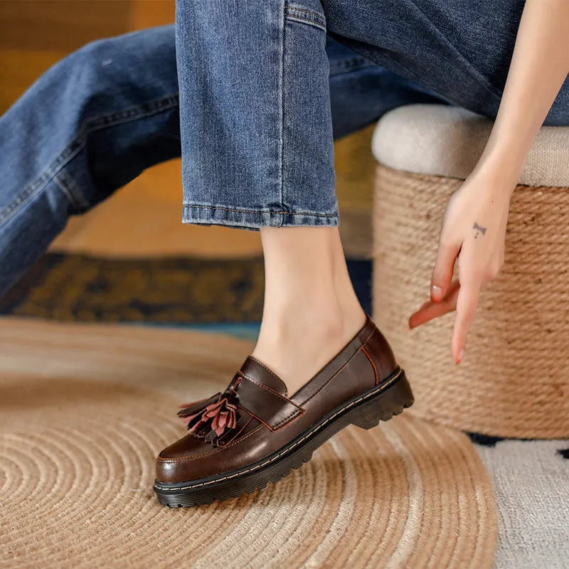 Women's brown leather loafers with tassel detail and a low chunky heel.