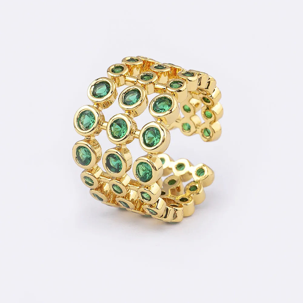 Copper ring with gold plating showing three-layer green stone setting and zircon detailing on wide band.