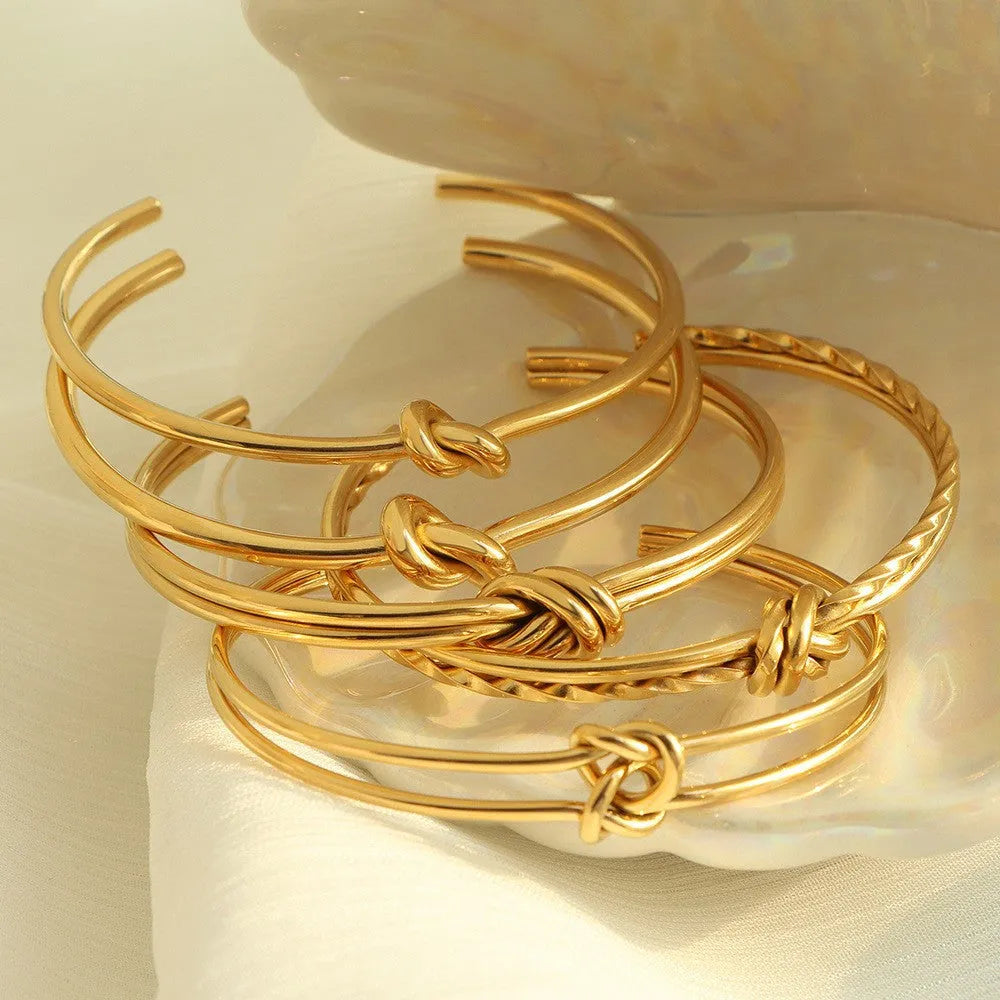 Adjustable stainless steel bracelet with 18K gold plating and knotted C-shaped open design